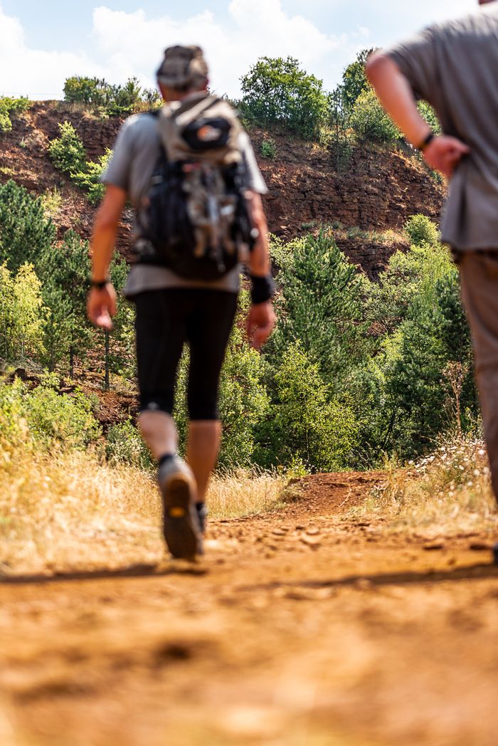 Wanderer auf dem Wanderweg, die rote Erde im Naturschutzgebiet Lalléngerbierg sichtbar